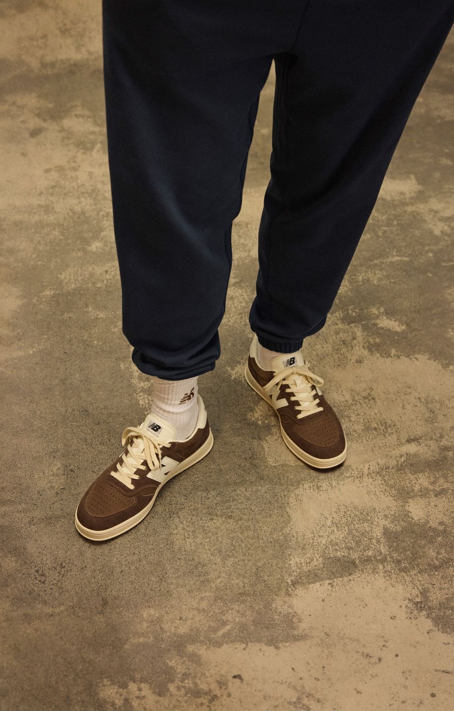 Knee down shot of a person sitting on a grungy studio backdrop 